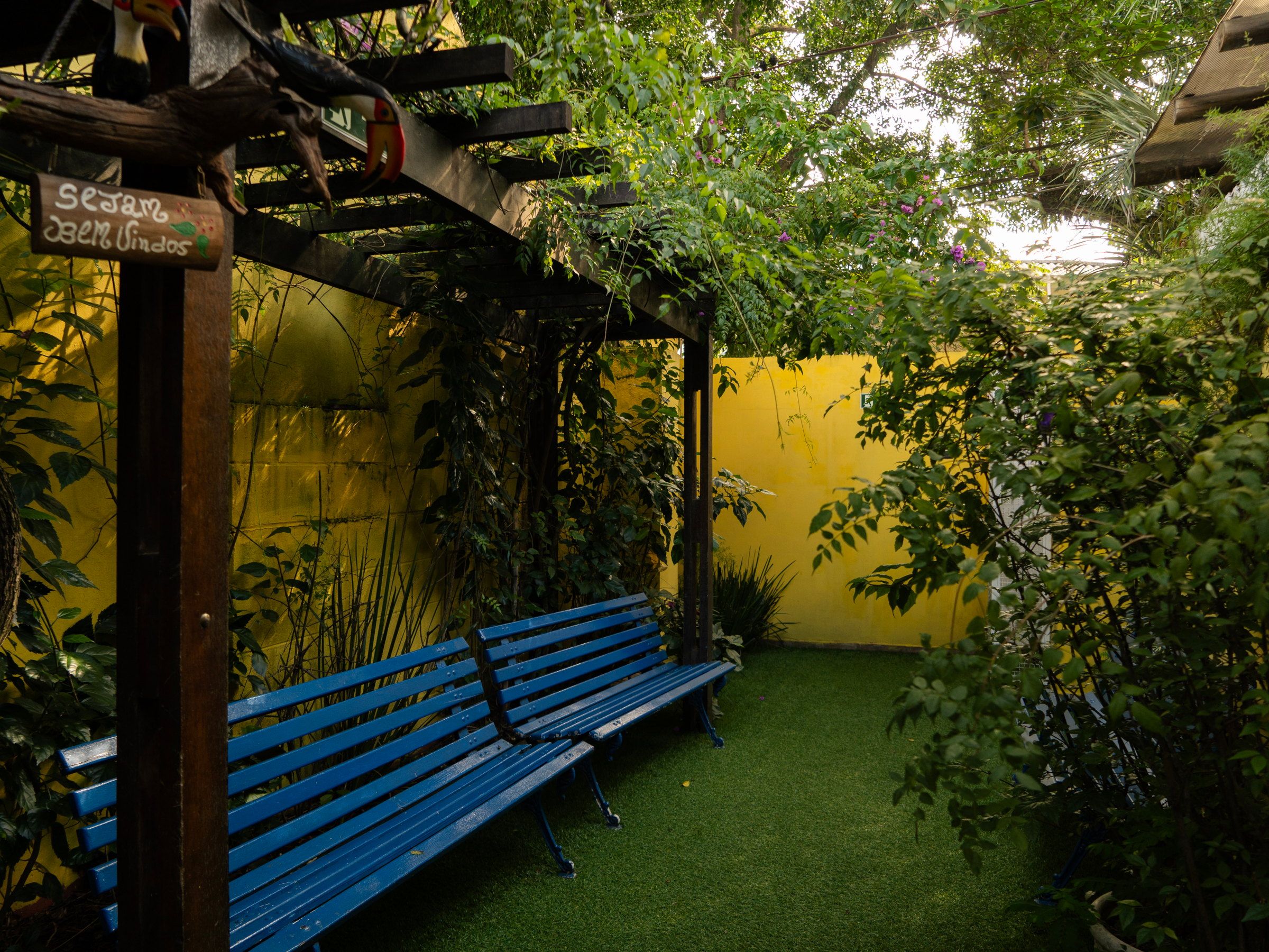 Banco azul e pergolado no jardim da Kûara