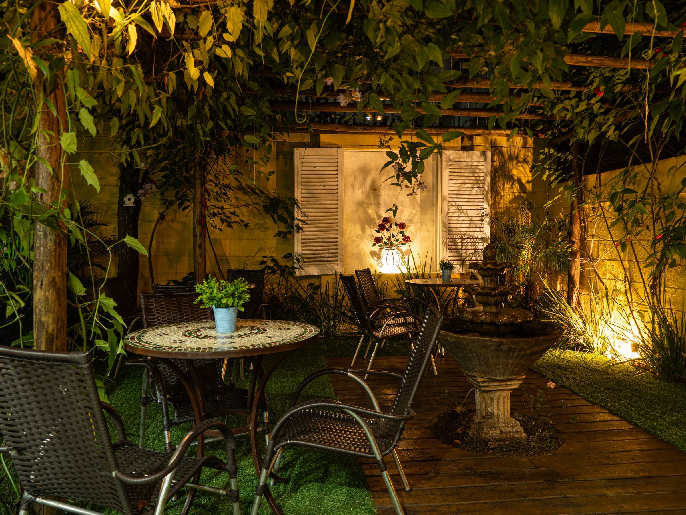 Deck da Kûara iluminado à noite, com mesa e cadeiras