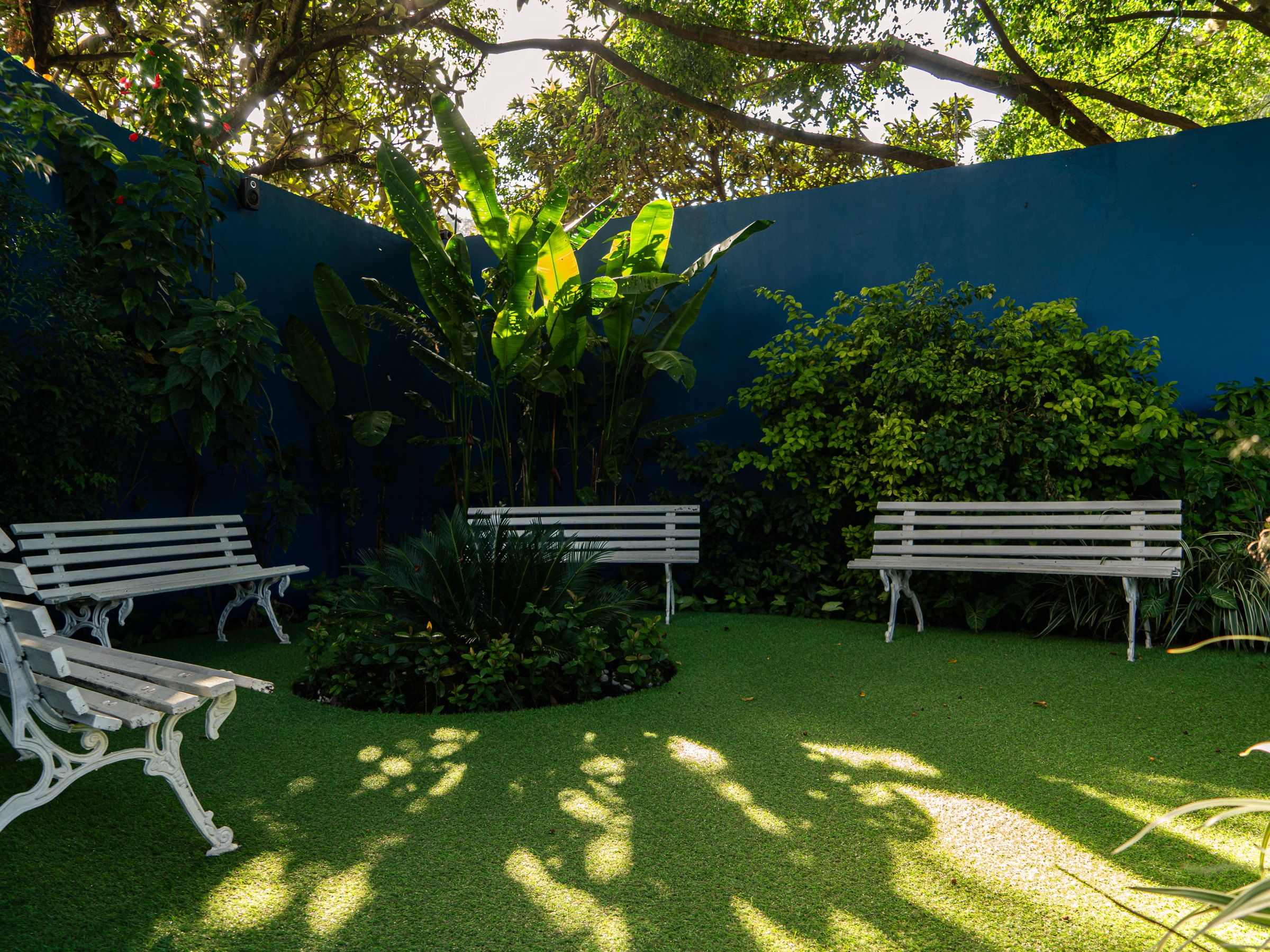 Bancos brancos em volta do canteiro do jardim do Residencial Espaço Saúde