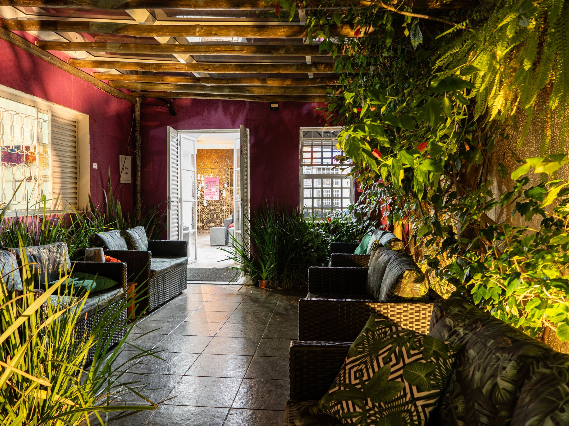 Sala da La Vie aberta para o jardim, com sofás e plantas